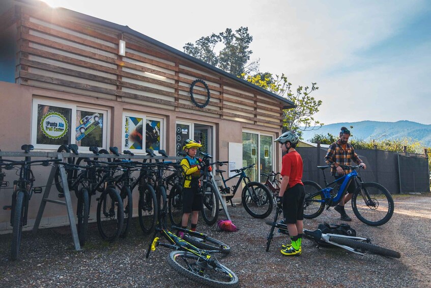 A building with a wooden facade, a bike rack with several bicycles, and a mountain in the background. 3