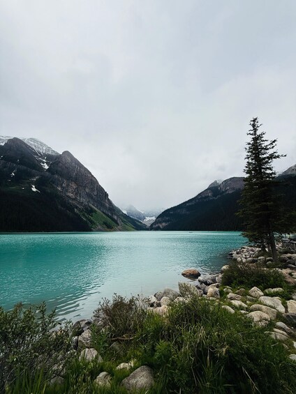 A mountain lake with clear turquoise water, surrounded by rocky shores and dense forests. 5