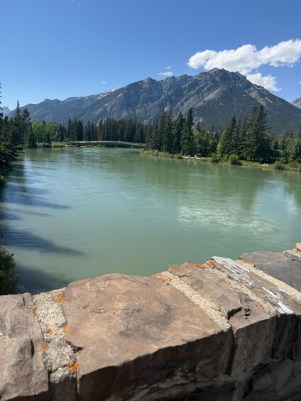 A river with mountains in the background and a rocky foreground. 3