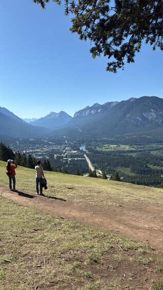 A mountainous landscape with a clear sky, a winding road, and a valley below. 2