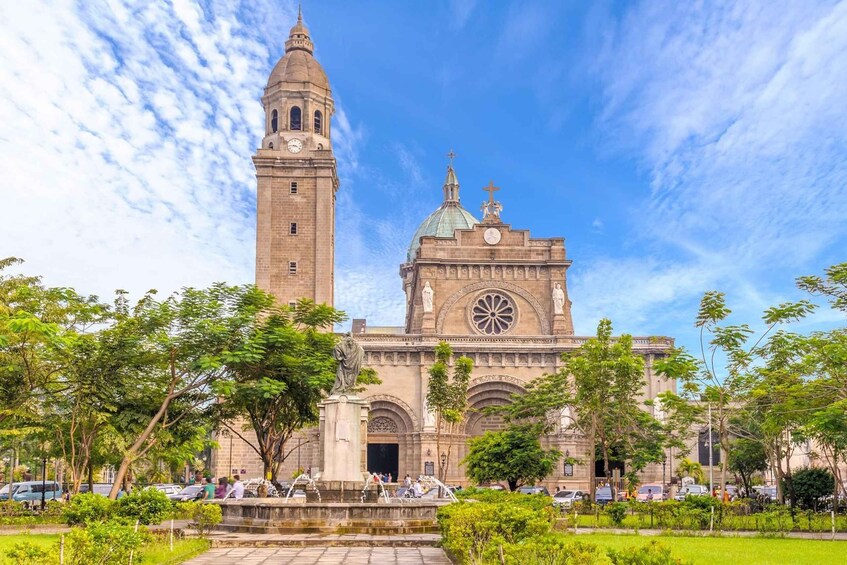 Una iglesia histórica con una imponente torre de campanas y un amplio ventanal circular. 3