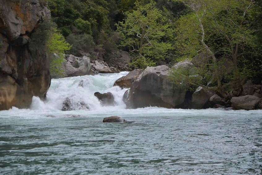 A waterfall cascading over rocks in a forested area. 2