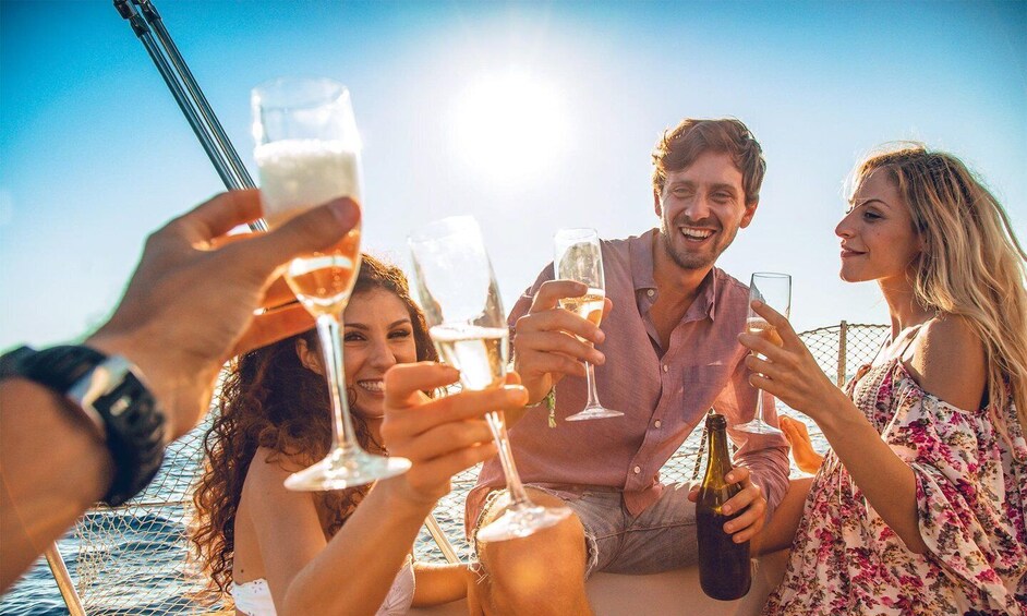 A group of people toasting with champagne glasses on a boat. 5