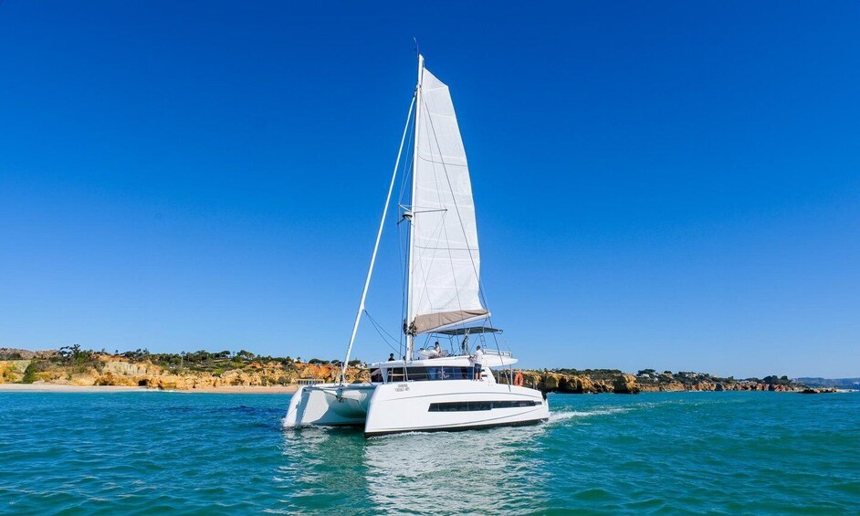 A white sailboat on turquoise water with a clear blue sky. 4