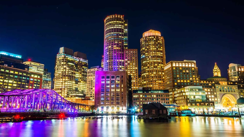 A nighttime cityscape with illuminated skyscrapers and a bridge with colorful lights. 3
