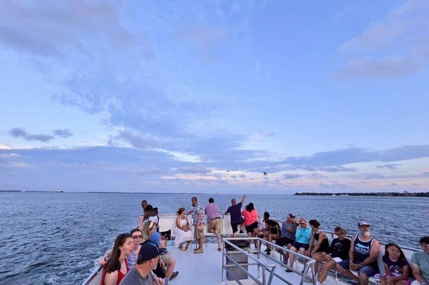 A group of people on a boat with a calm sea and a clear sky in the background. 2