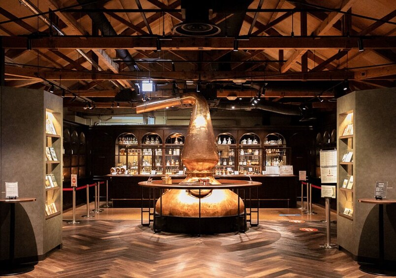 A distillery with a large copper still in the center, surrounded by shelves of bottles and a wooden floor. 3