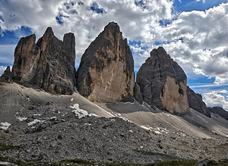 A rugged mountain landscape with prominent rock formations and patches of snow. 5