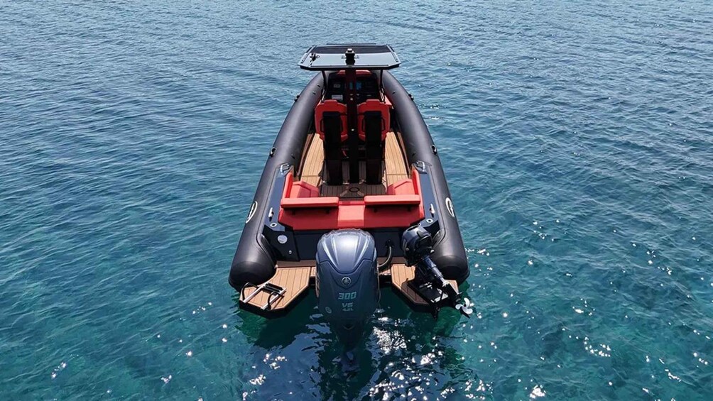 A motorboat with a canopy and red seating on clear blue water. 4