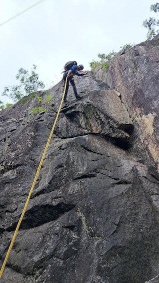 A person rappelling down a steep rock face. 5