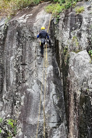 A person rappelling down a rocky cliff. 3