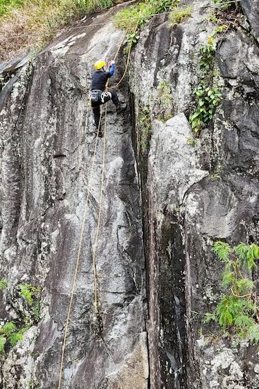A person rappelling down a rocky cliff. 2