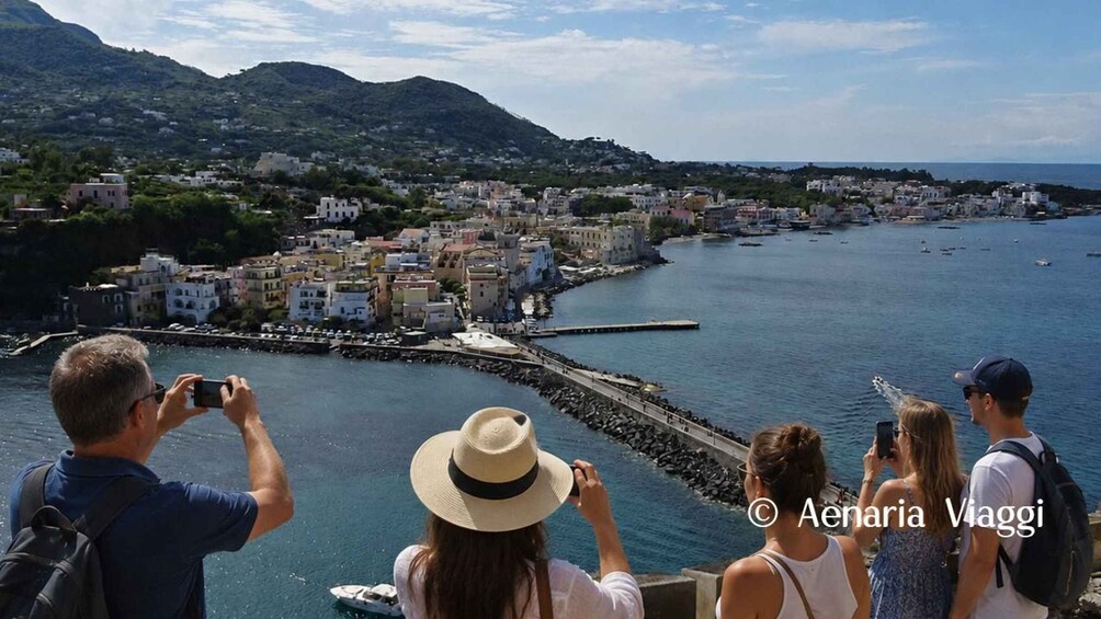 A coastal town with a pier, boats, and a mountainous backdrop. 3