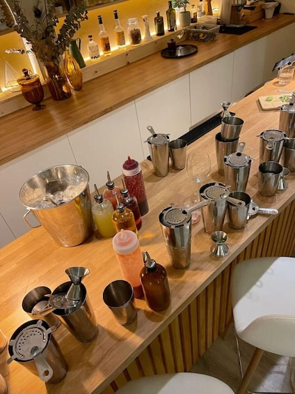 A bar counter with various cocktail-making tools and bottles. 3