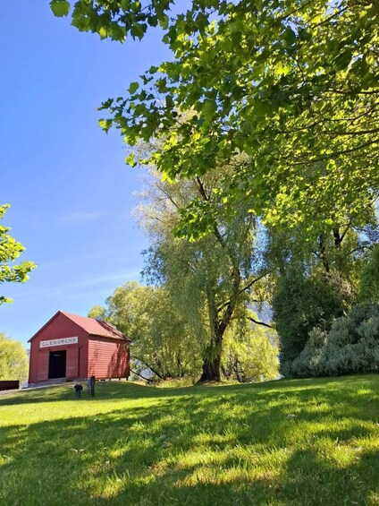 A red barn labeled 'Glenorchy' in a grassy field with trees in the background. 3