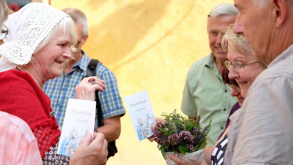 A person holding a card and a bouquet of flowers. 2