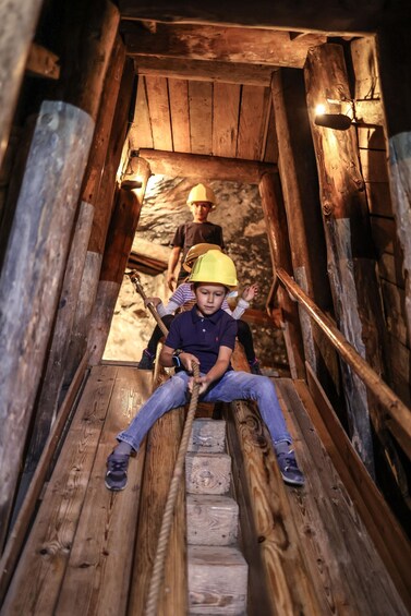 A wooden staircase with a person wearing a hard hat sitting on the steps. 4