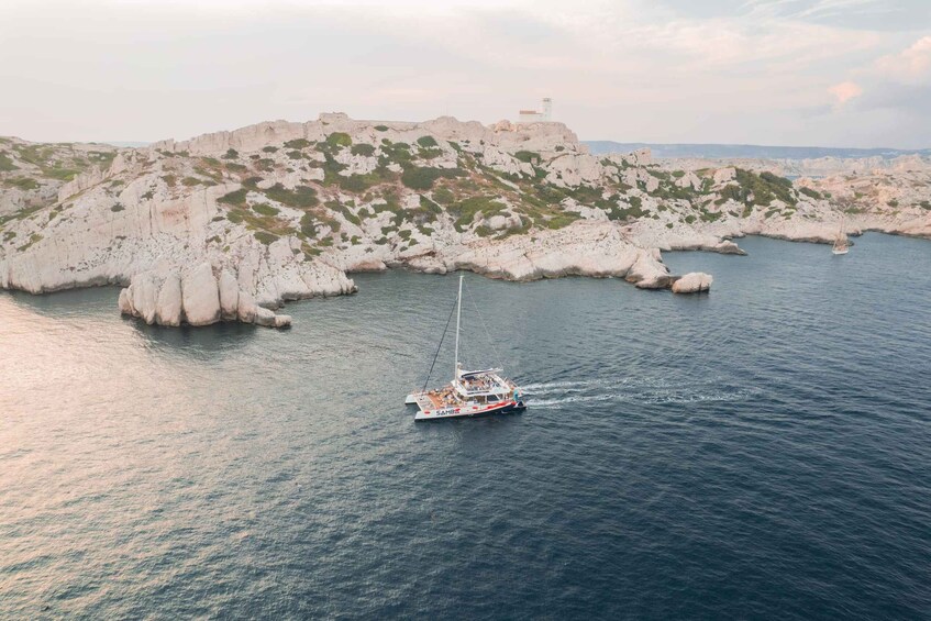 A sailboat named 'SAHBA' navigating near rocky coastlines with a lighthouse in the background. 1