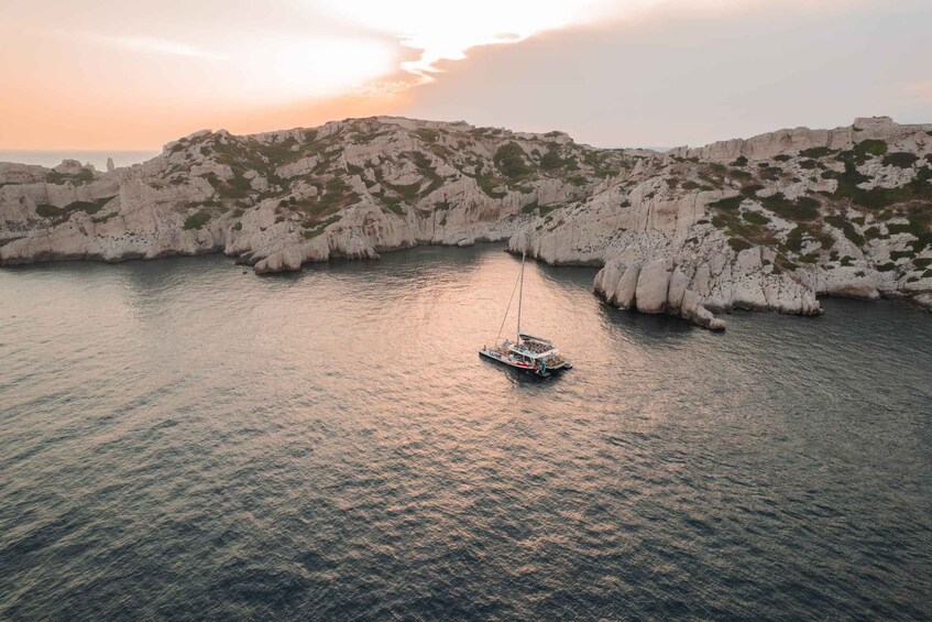 A boat in calm waters surrounded by rocky cliffs. 4