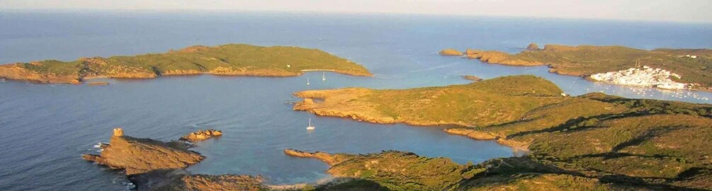 A coastal landscape with rocky outcrops and a small settlement by the sea. 2