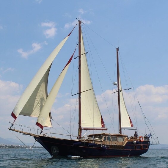A sailing boat with multiple sails on a calm sea. 1