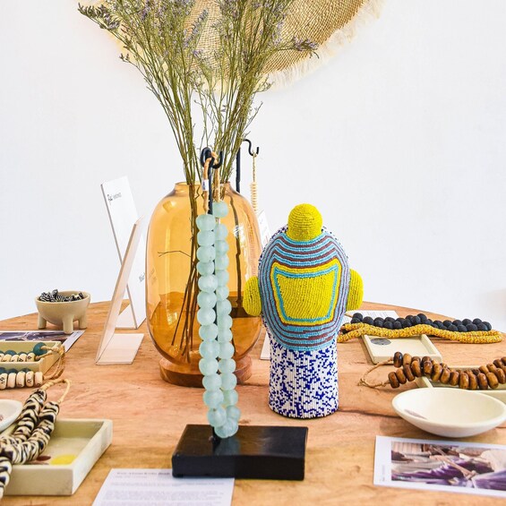 A table with various decorative items including a vase with lavender, a crocheted figure, and beaded necklaces. 5