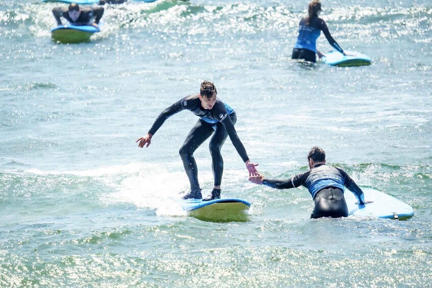 Surfers on blue and yellow surfboards in the ocean. 1