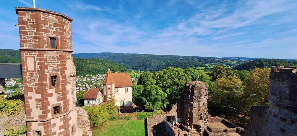 A stone tower, a church, and ruins in a hilly landscape. 1