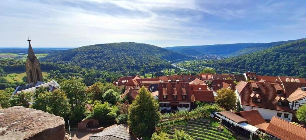 A village with traditional houses, a church, and rolling hills in the background. 5