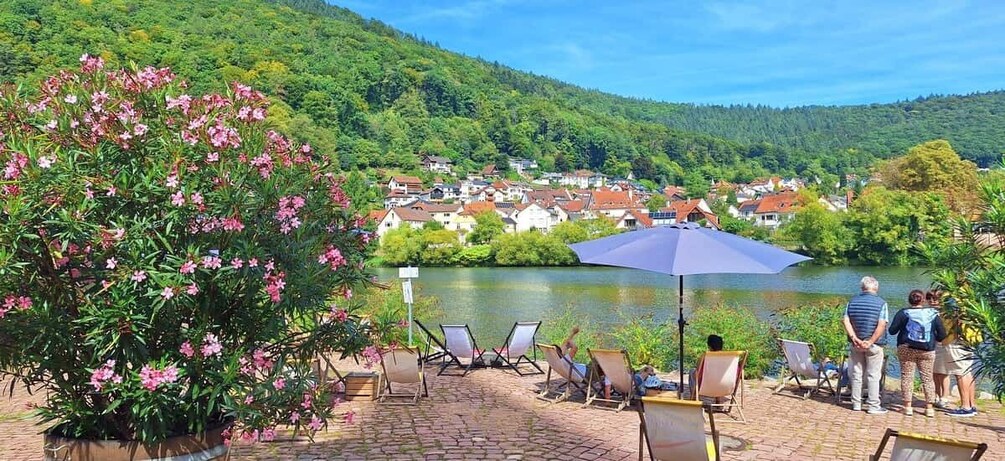 A riverside patio with chairs, a table, and a large umbrella. 2