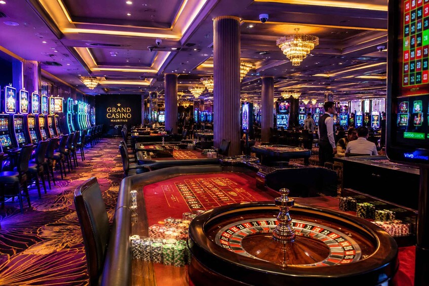 A casino with roulette tables, slot machines, and a blackjack table. 5