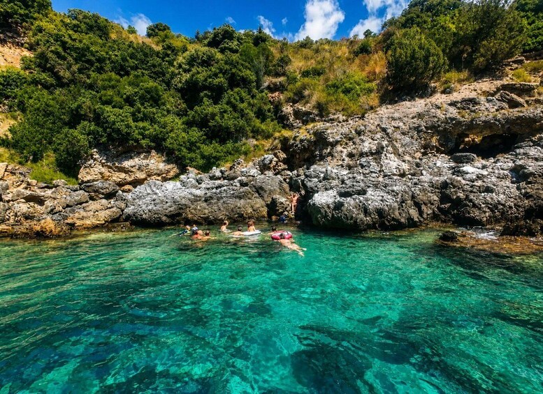 Clear turquoise water, rocky cliffs, and lush greenery. 3