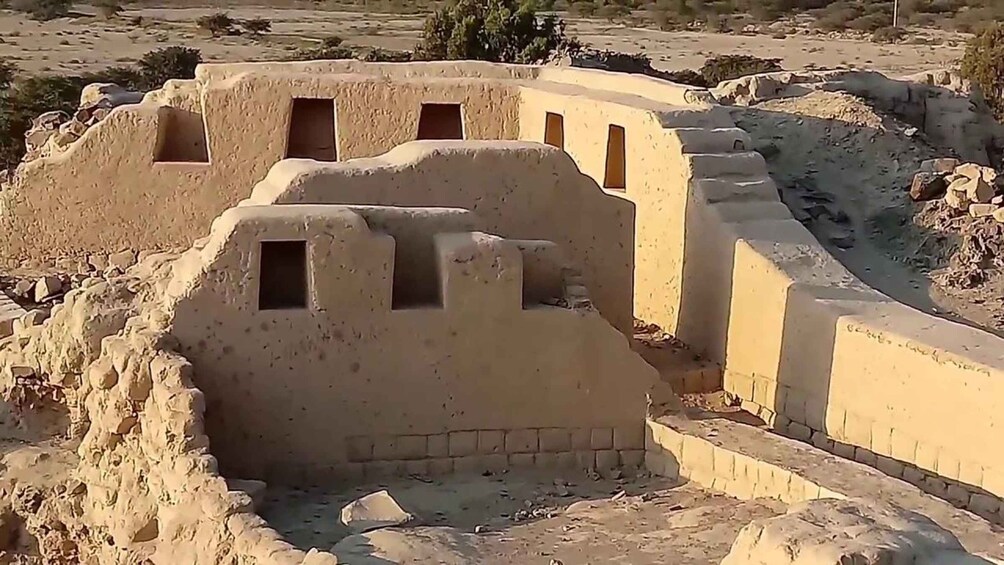 A desert landscape with ancient mud-brick structures. 2