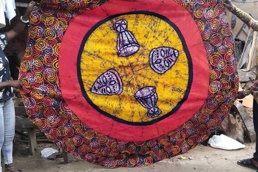 A colorful tapestry with a central yellow circle and four purple objects. 2