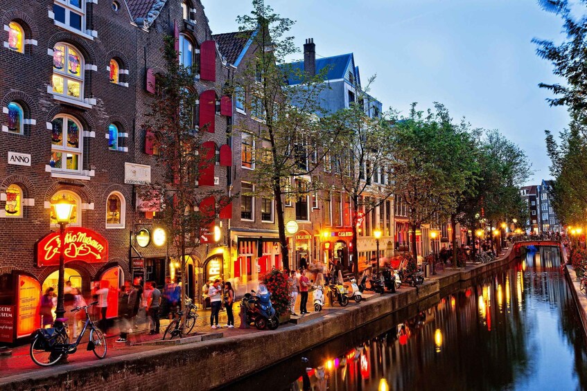 A canal with buildings and people along the walkway. 2