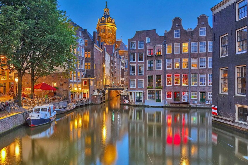 A canal with a boat, buildings with red doors, and a tower with a dome. 4