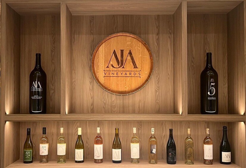 A wooden wine rack with bottles and a central logo. 4