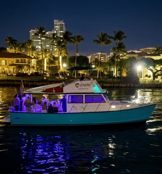 A boat named 'Delphina' on water with a city skyline in the background. 1