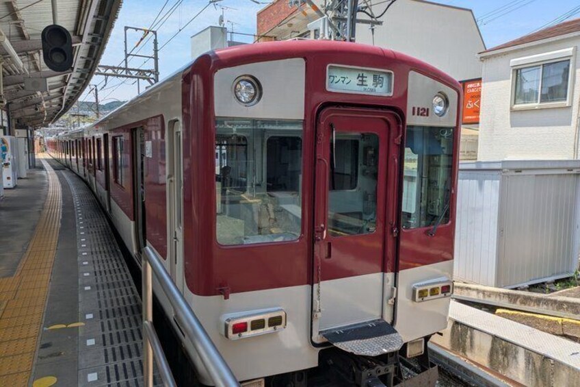 A red and white train at a station platform with a clear sky. 2