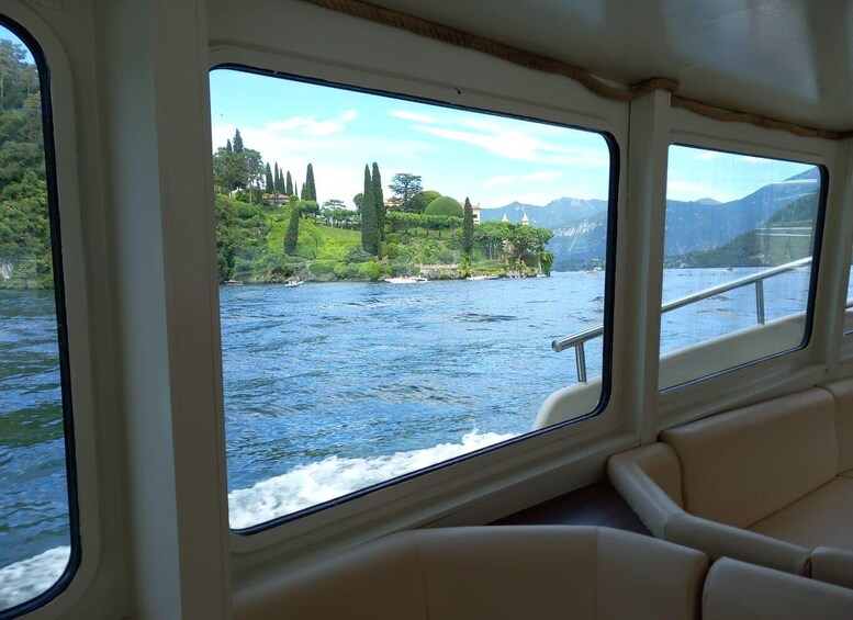 A boat's interior with a view of a calm river, green banks, and distant mountains. 5
