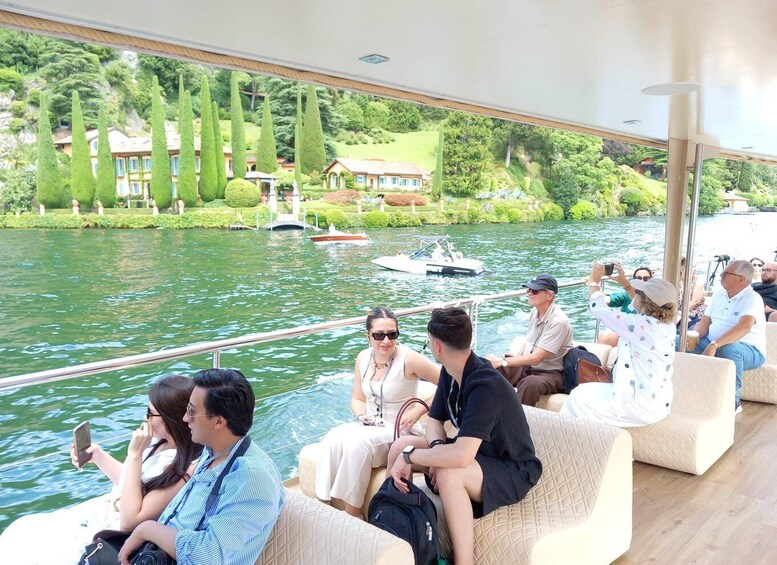 A group of people on a boat, with a lake and houses in the background. 3