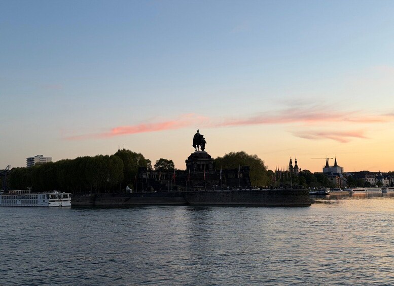 A river with a statue and buildings in the background. 2
