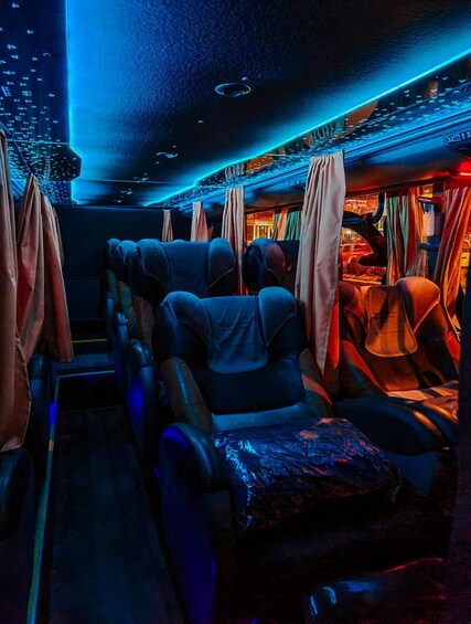 A train interior with blue lighting, leather seats, and curtains. 4