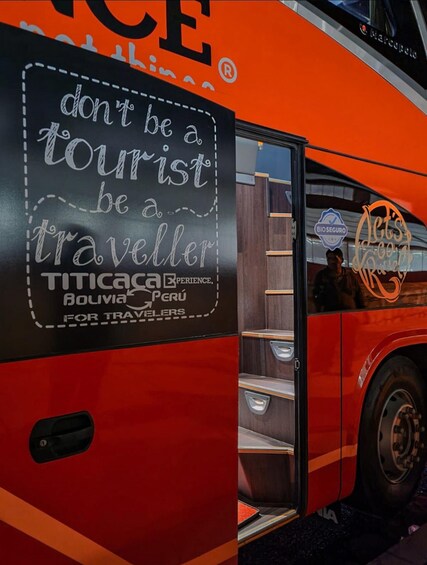 A red bus with a sign that reads 'don't be a tourist be a traveller' and 'TITICACA PERU FOR TRAVELLERS.' 2