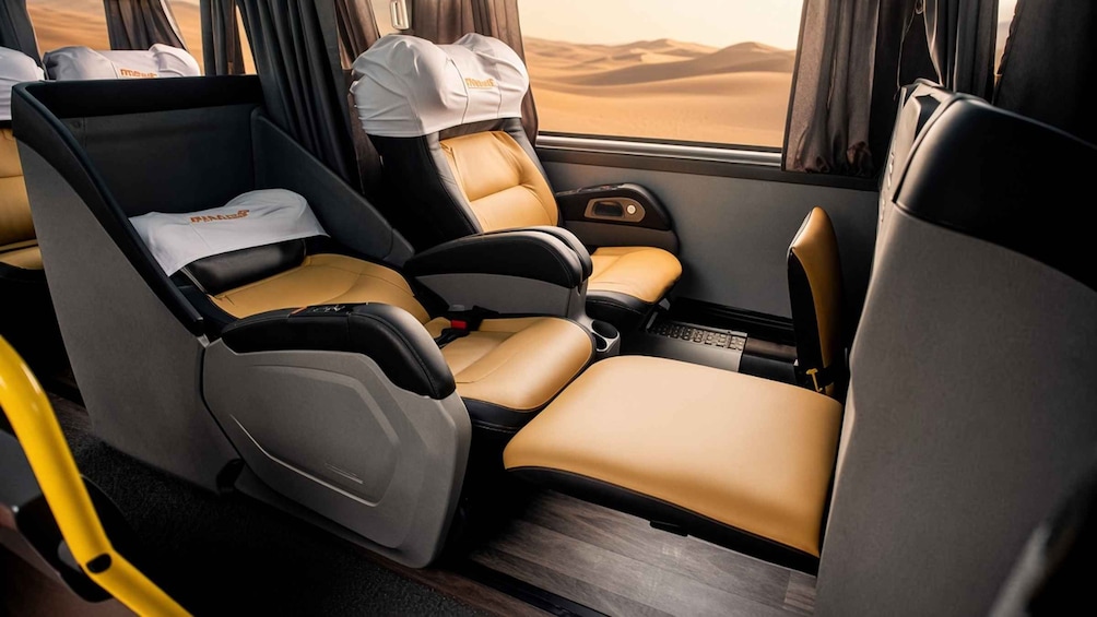 A luxury vehicle interior with two seats, a sunroof, and a view of a desert landscape. 2