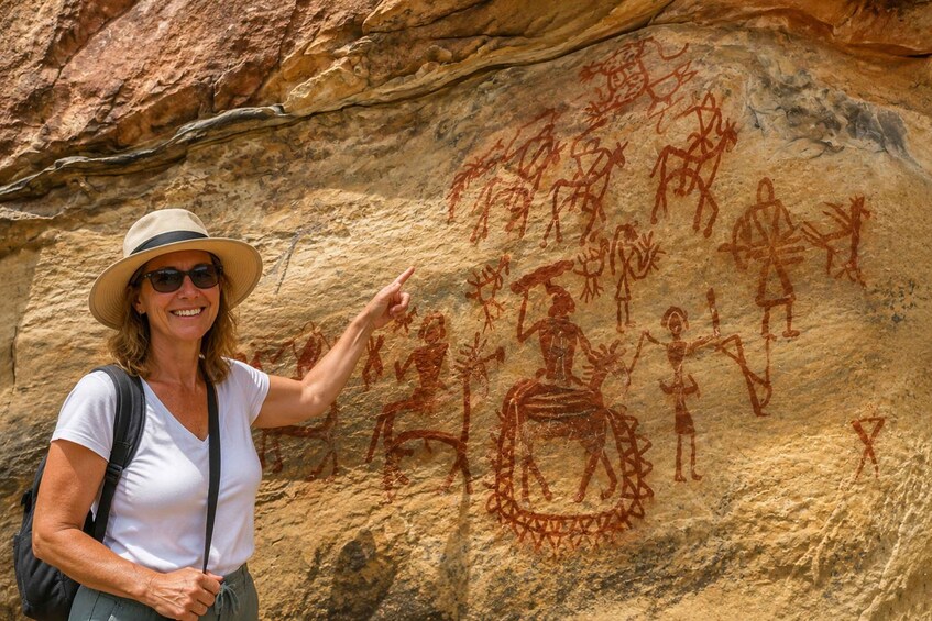 A person pointing at ancient rock art. 5