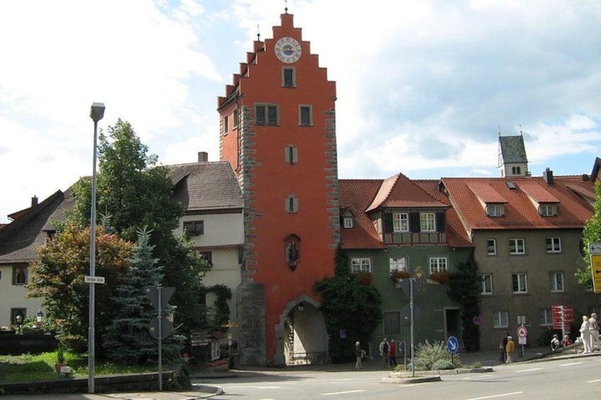 A historic building with a clock tower, surrounded by other buildings with red roofs. 3