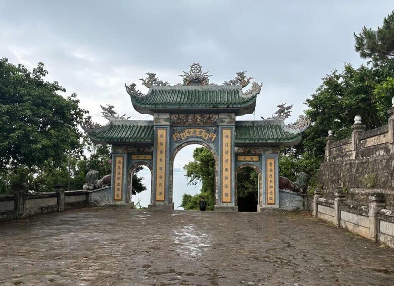 A traditional Chinese gate with ornate decorations and inscriptions, leading to a pathway. 5