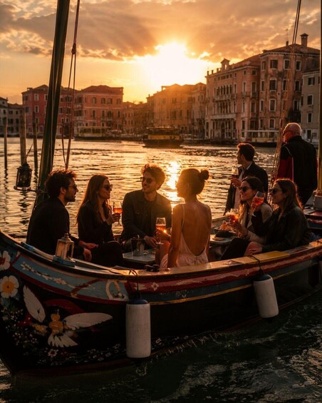 A group of people on a colorful boat with a sunset in Venice. 1