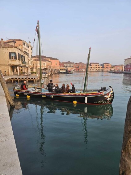 A gondola with passengers on a canal in Venice. 5